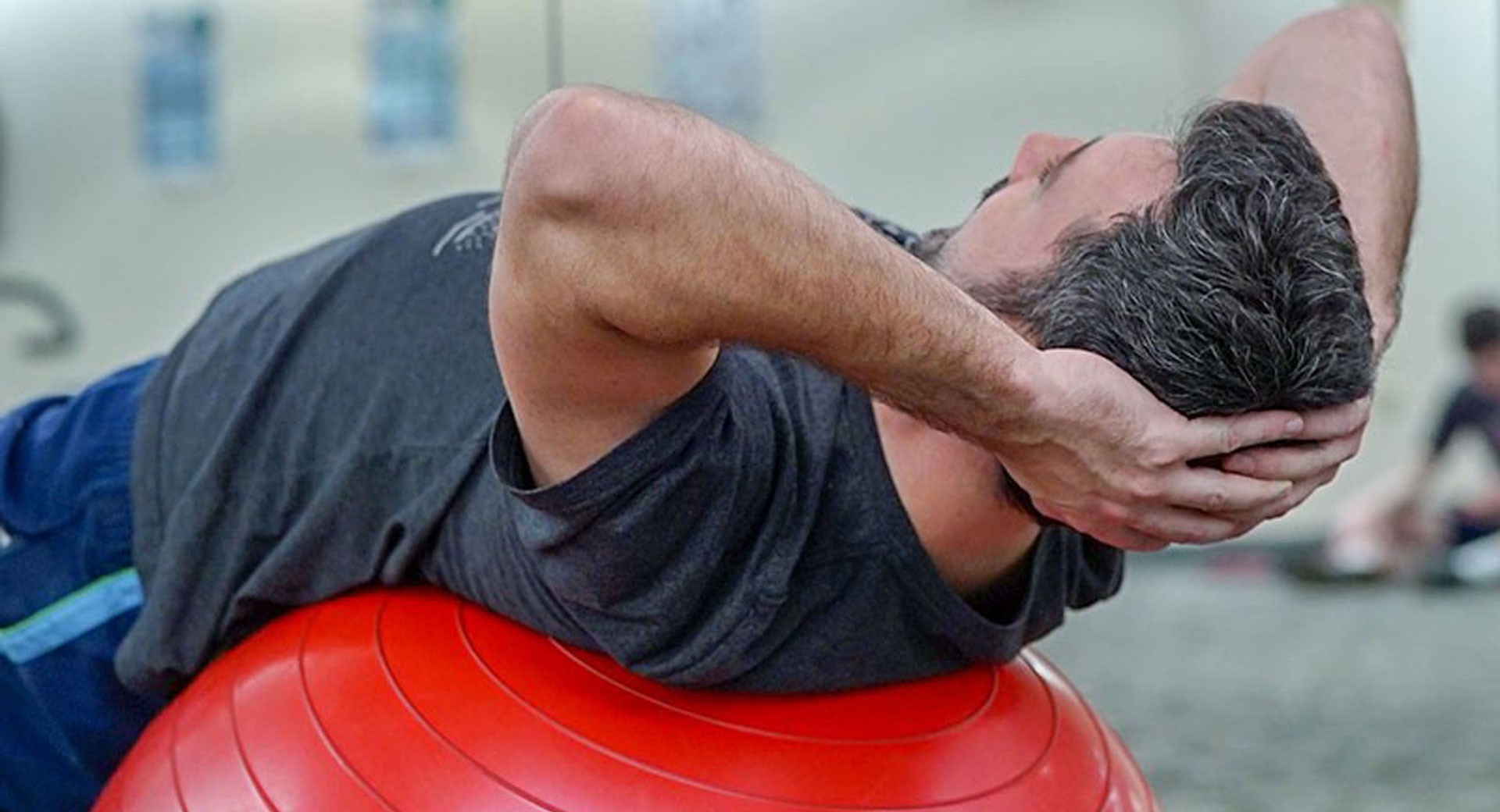 Physiotherapie Übung mit Gymnastikball – Person führt Rückenübung aus, phd physio c heath head