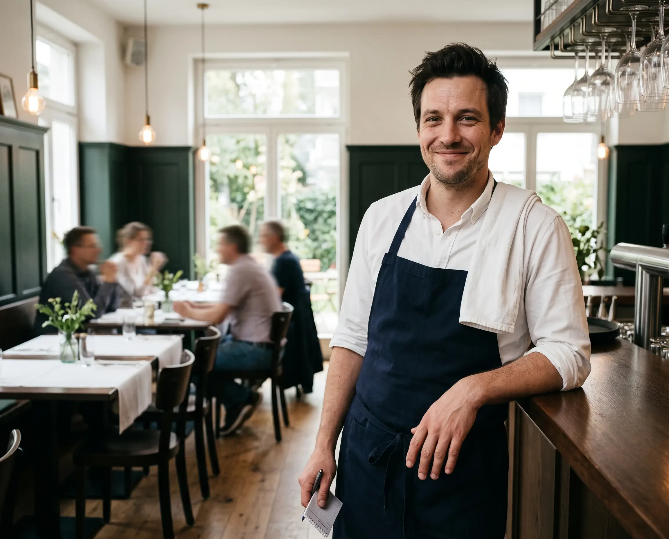 Onlineanzeigen: Sympathischer Kellner im modernen Restaurant, aufgenommen von Gemini AI (KI-generiert)
