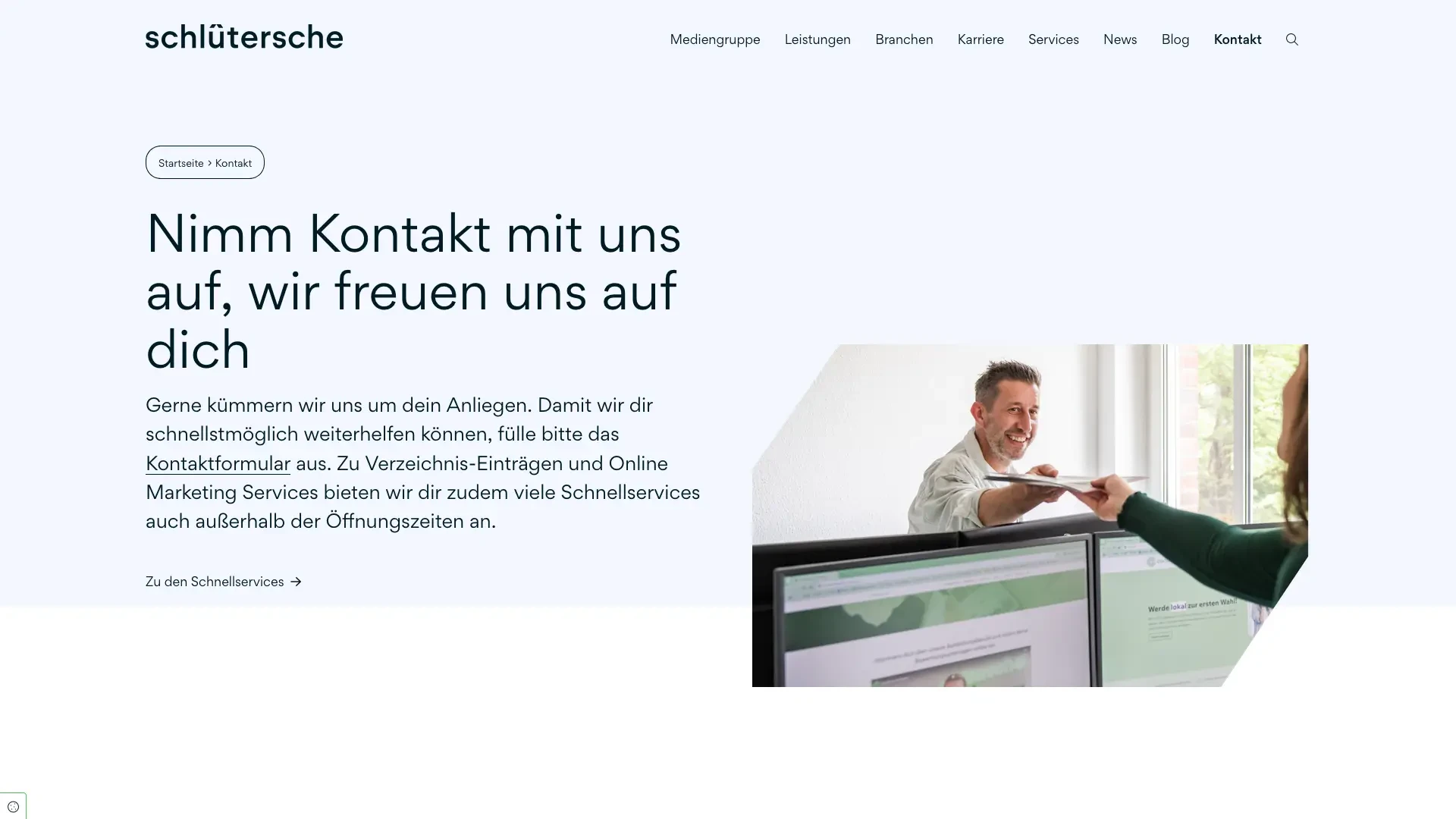 Mitarbeiter der Schlütersche Mediengruppe im Büro bei der Übergabe von Unterlagen