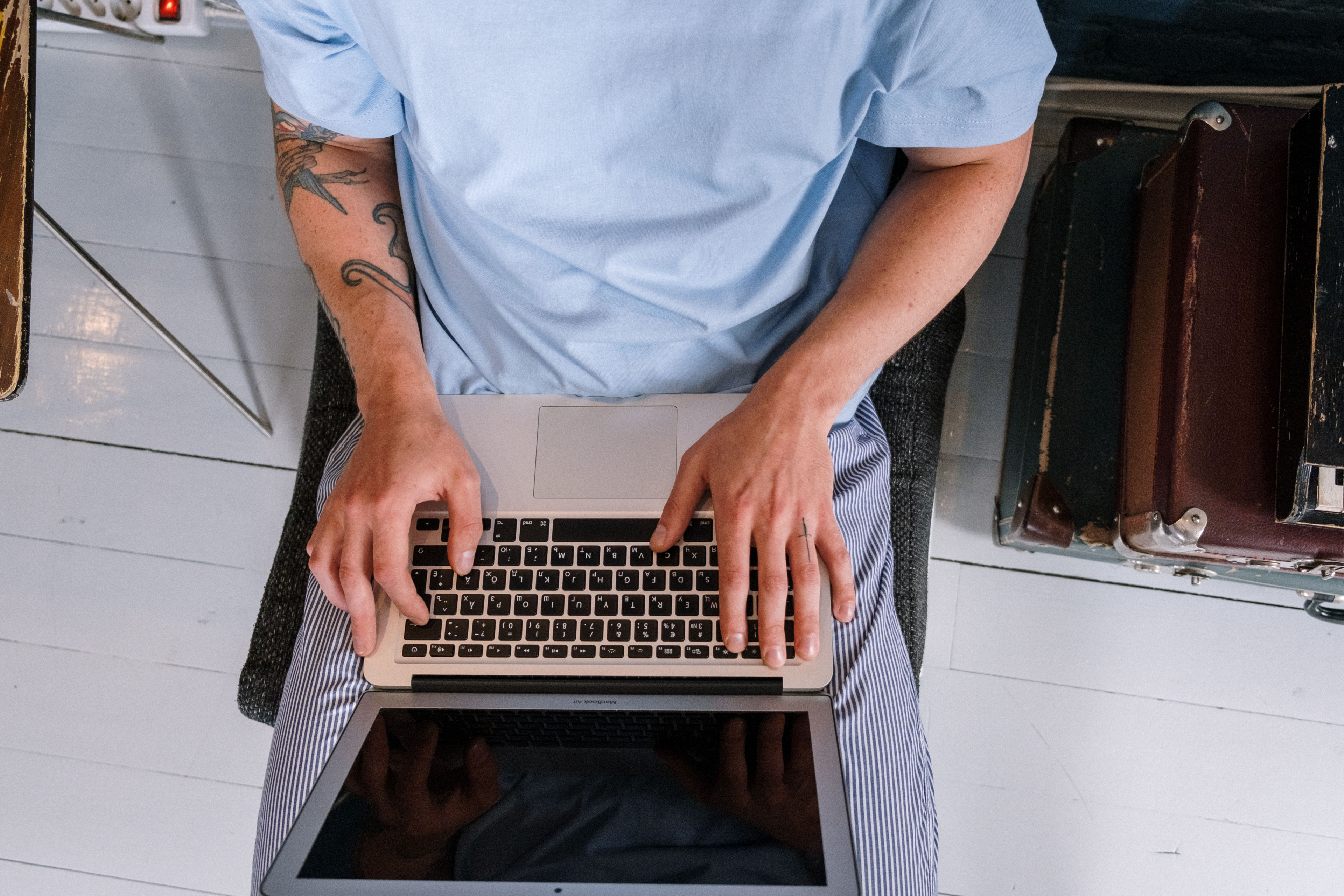 Person mit Laptop arbeitet am Schreibtisch