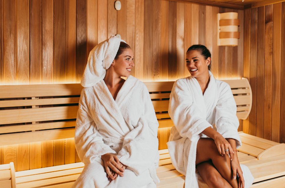 Zwei Frauen im Bademantel entspannen in einer modernen Sauna