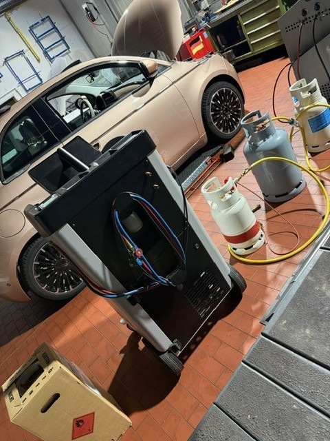 Kfz-Werkstatt mit Fiat 500, Klimaservicegerät und Gasflaschen