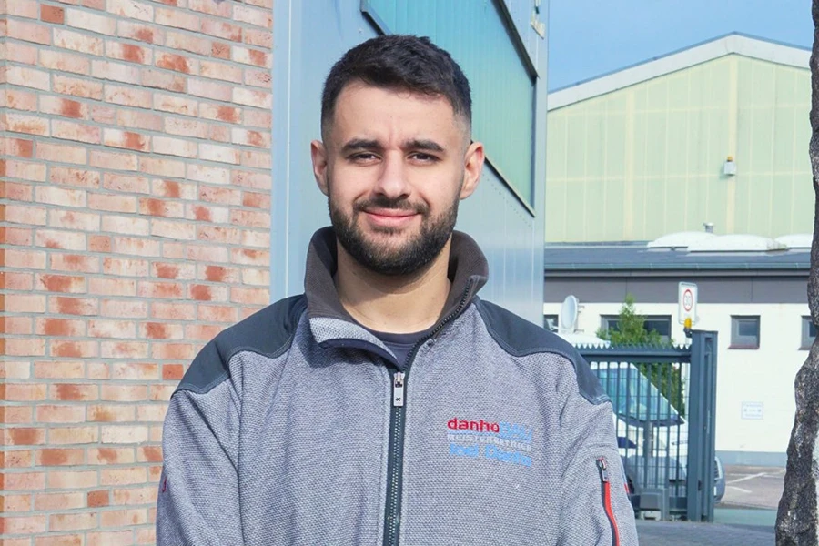 Mann in grauer Jacke vor einem Gebäude Mann in grauer Jacke vor einem Gebäude