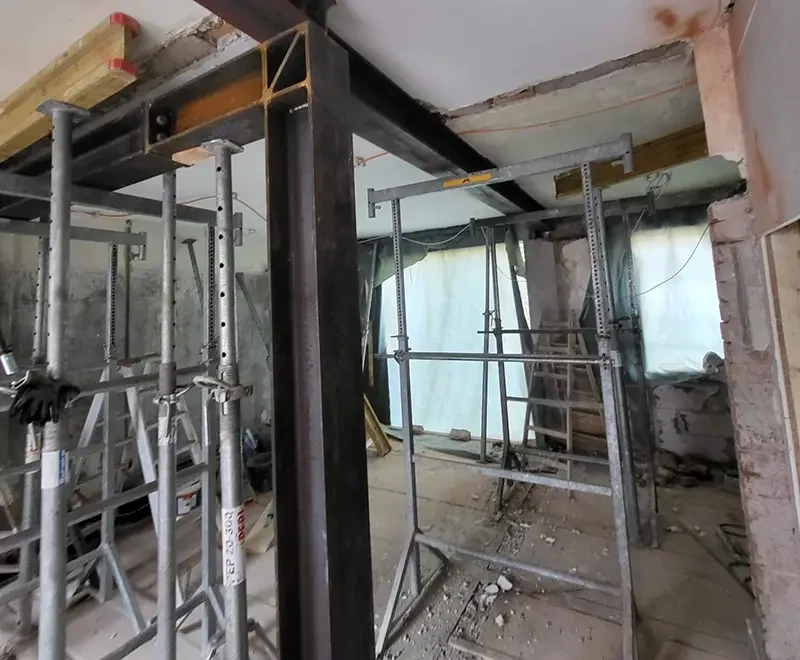Baustelle mit Stahlträgern und Baugerüsten während einer Renovierung im Innenbereich