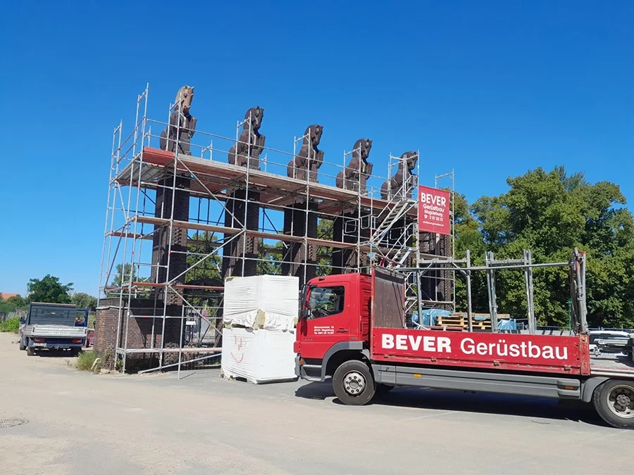 Gerüstbau am Denkmal mit Pferdefiguren und BEVER Gerüstbau LKW vor blauem Himmel