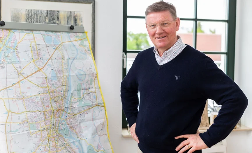 Josef von Beverfoerde steht neben einer großen Landkarte in einem Büro