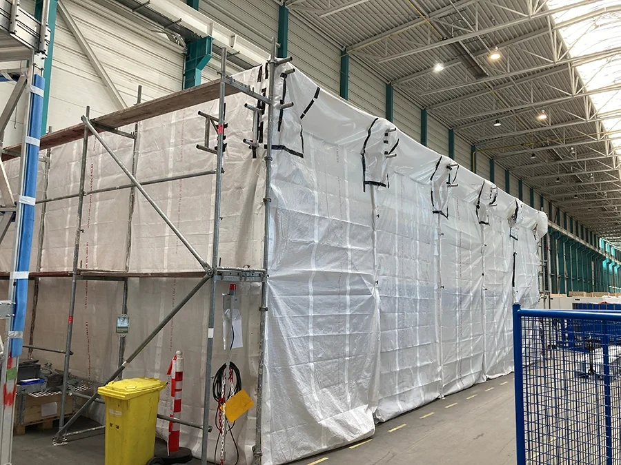 Einhausung in der Industriehalle mit Gerüst und Schutzfolie