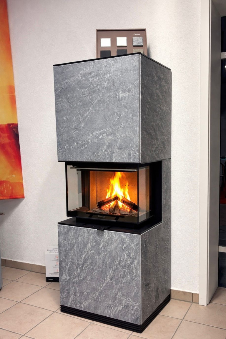 Moderner Kaminofen mit Glasfront und brennendem Feuer in einem Ausstellungsraum