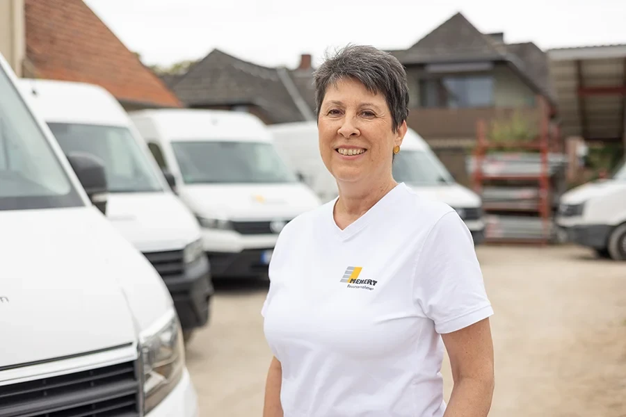 Claudia Hykel von HENERT Gebäudereinigung vor Firmenfahrzeugen