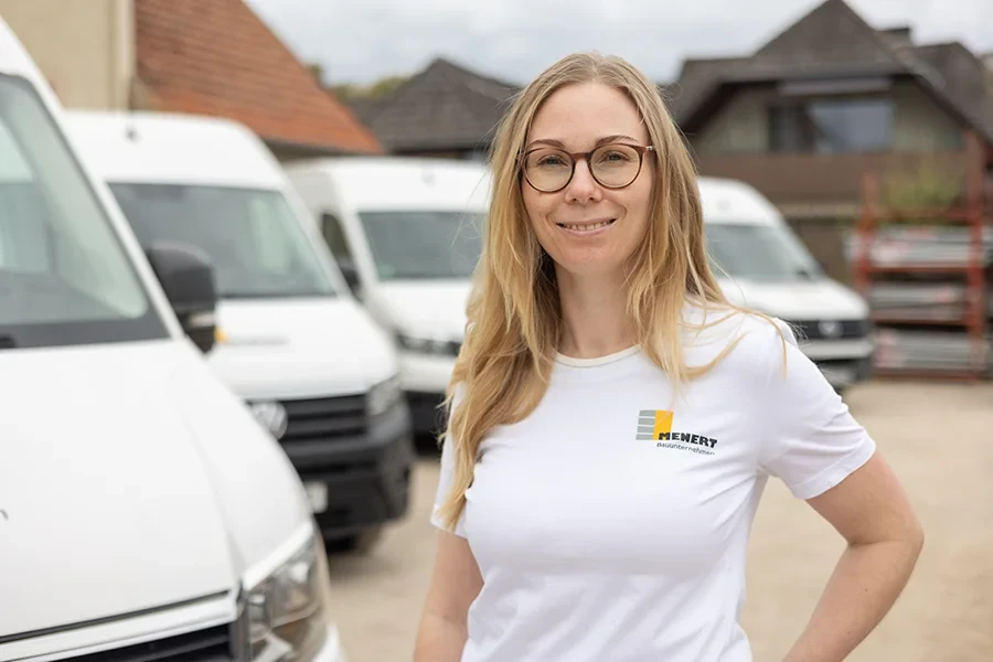 Kristina Lenarz im Mehnert Bauunternehmen T-Shirt vor Firmenfahrzeugen