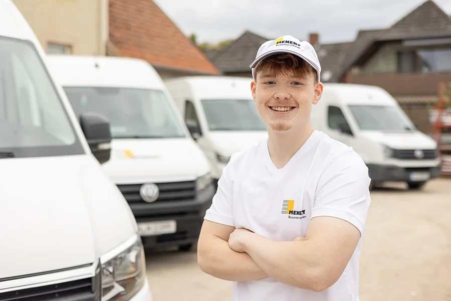 Jannis Ortner von Menet Bauunternehmen vor Firmenfahrzeugen