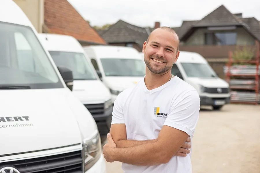 Steven Pollaschek vor Transportern von Meiert Bauunternehmen