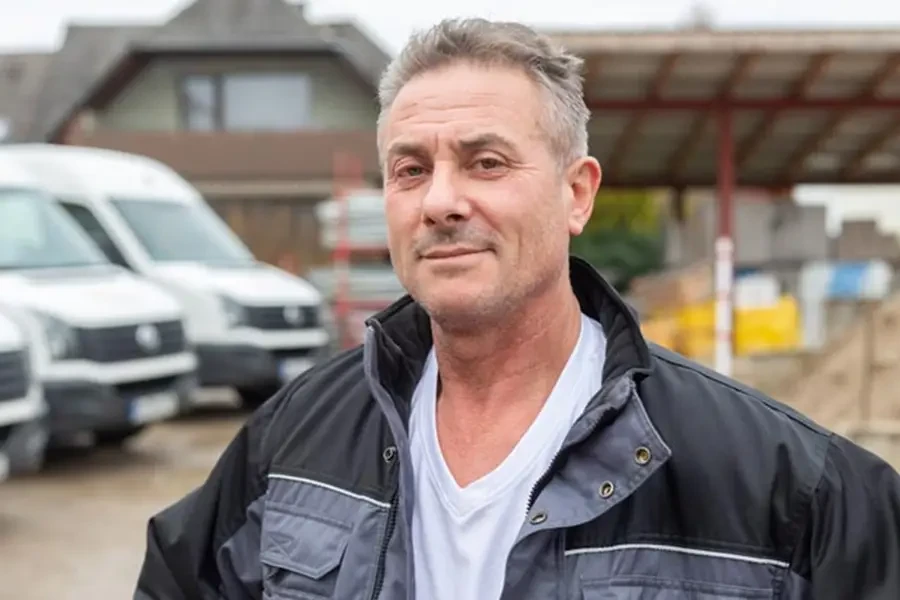 Haki Mjekiqi auf einer Baustelle im Freien mit Arbeitsjacke