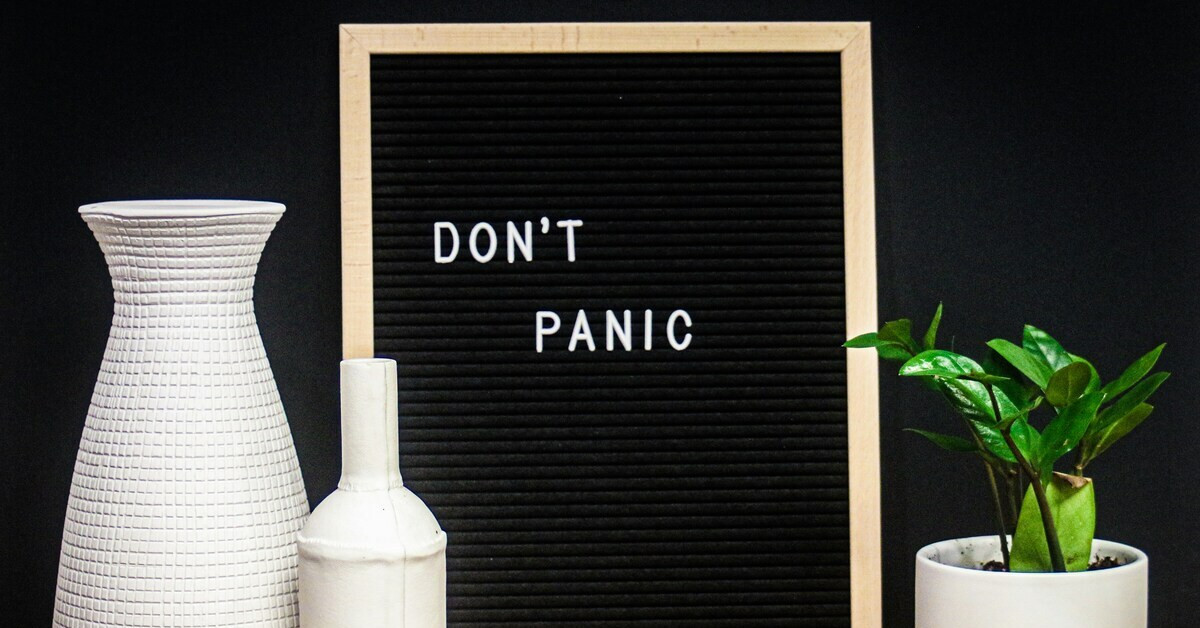 Schwarzes Letterboard mit der Aufschrift 'Don't Panic'