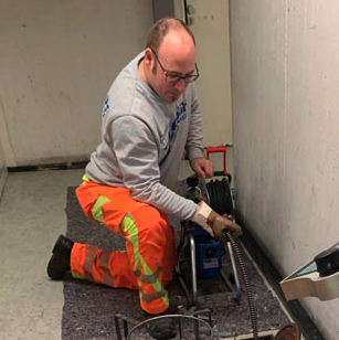 Experte bei der Arbeit mit Rohrreinigungsmaschine in einem Technikraum