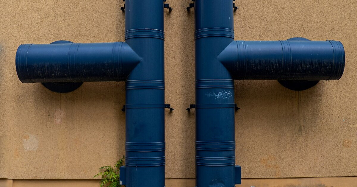 Rohrverbindungen und Steckverbindungen an einer Gebäudewand aus blauen Rohren