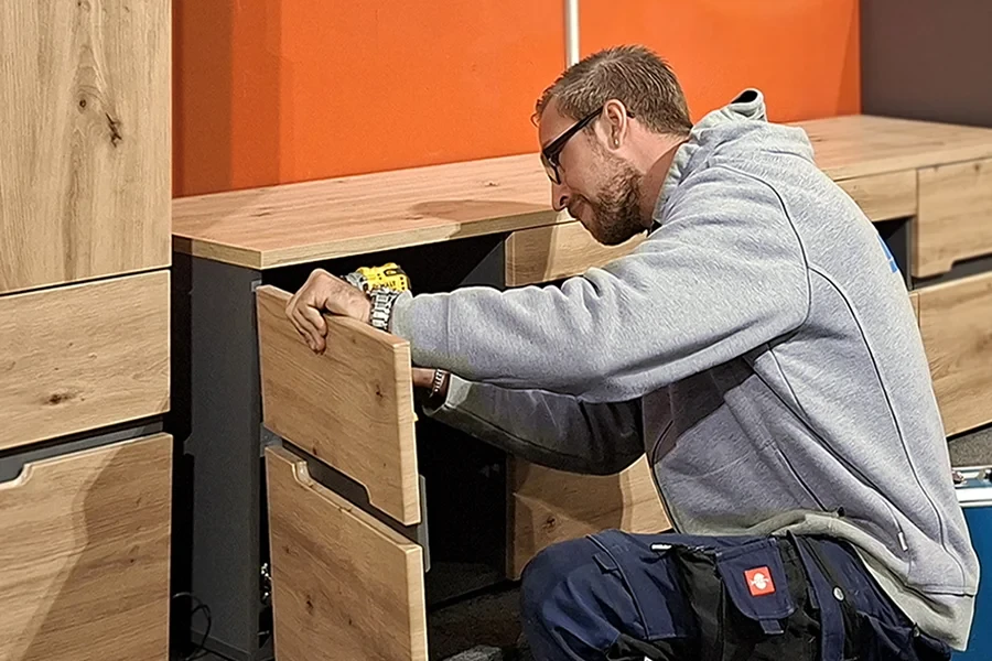Schrankmontage – Handwerker montiert einen Holzschrank