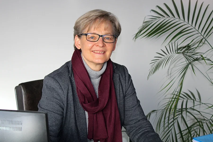 Porträt von Dagmar Stecker im Büro mit Schal und Blazer
