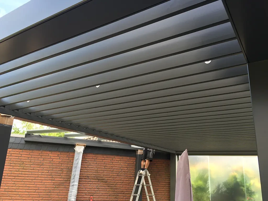 Montage eines modernen Lamellendachs an einer Hauswand