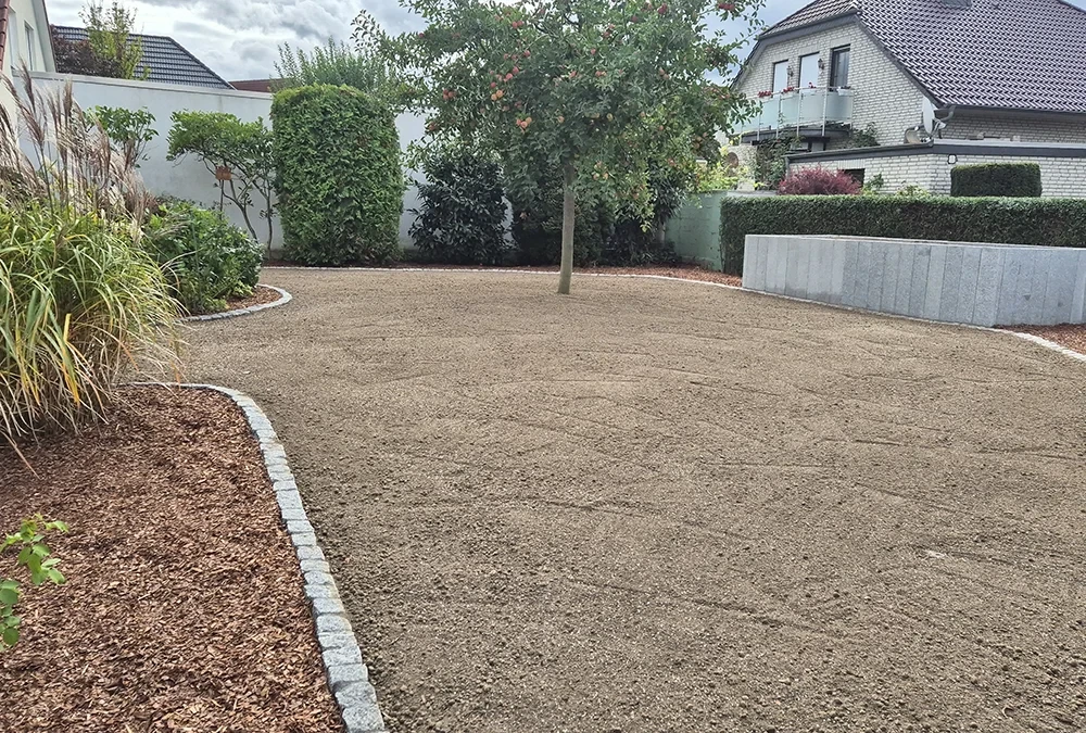Auffahrt im Garten mit Kiesbelag und Baum, moderne Gestaltung