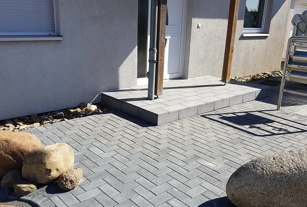 Moderner Hauseingang mit gepflasterter Eingangstreppe und Steinboden