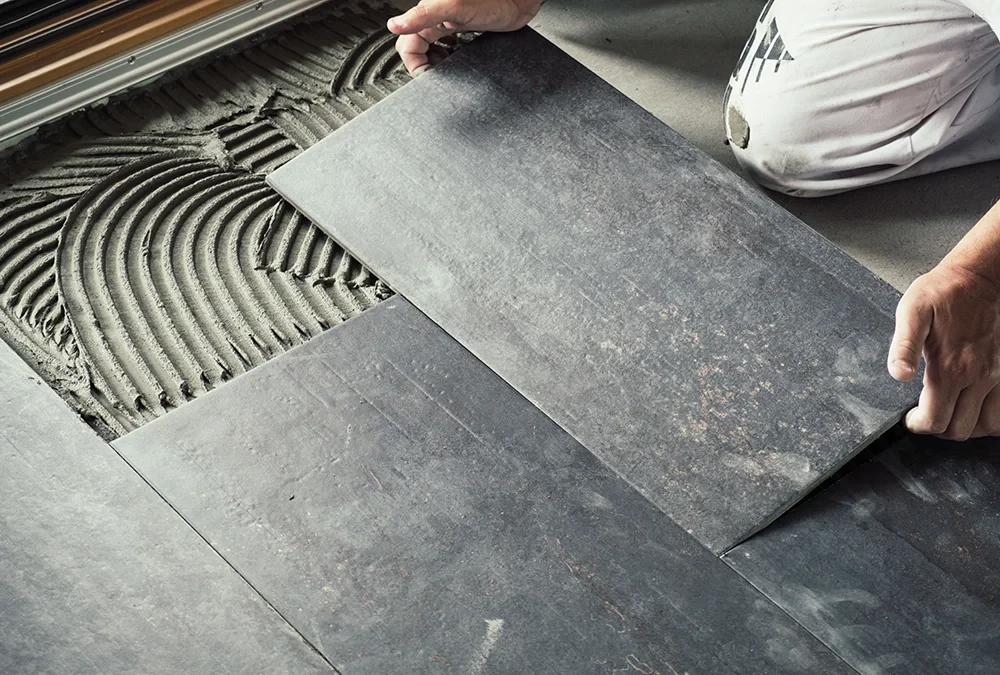 Handwerker beim Fliesen legen auf frischem Fliesenkleber