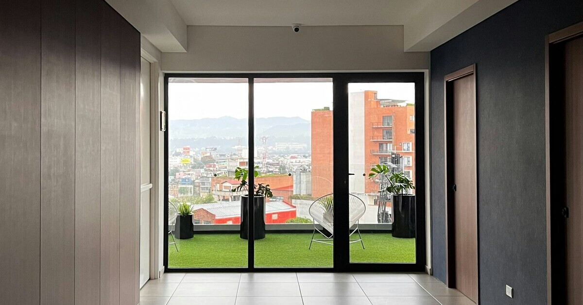 Moderner Balkon mit Kunstrasen, Pflanzen und Stadtblick