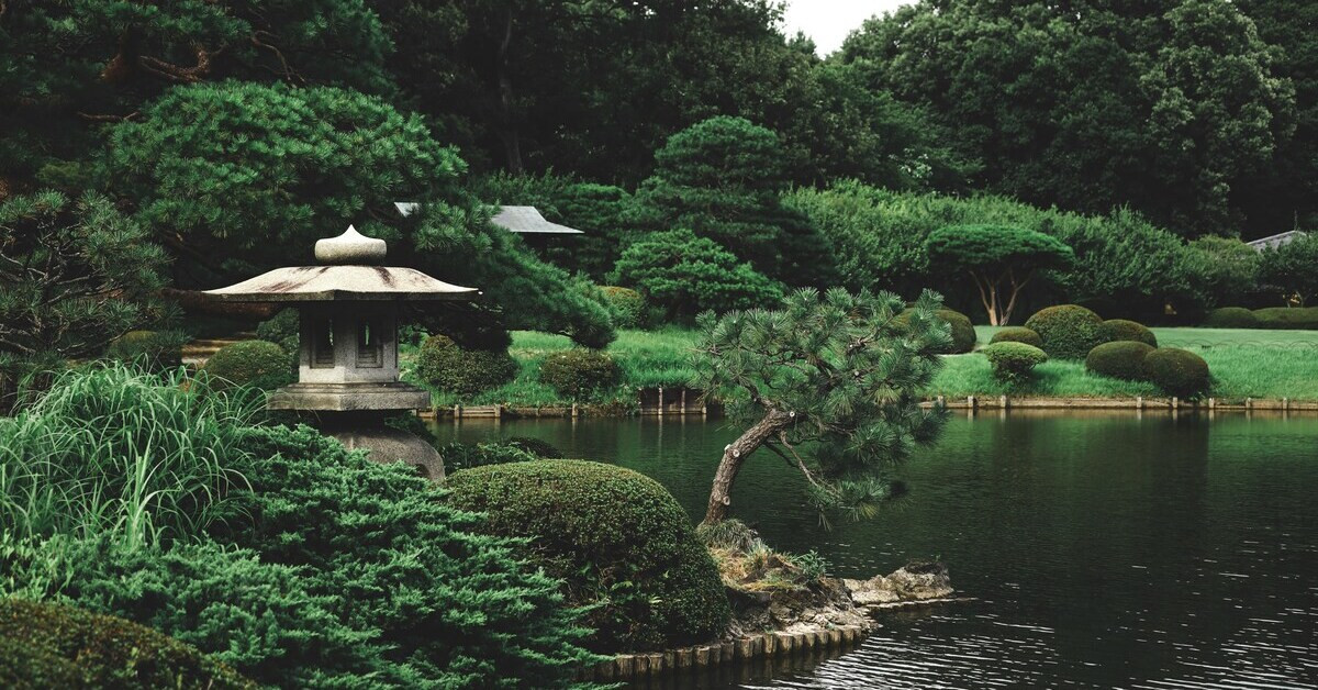 Japanischer Garten mit traditioneller Steinlaterne, Teich und gepflegten Bäumen