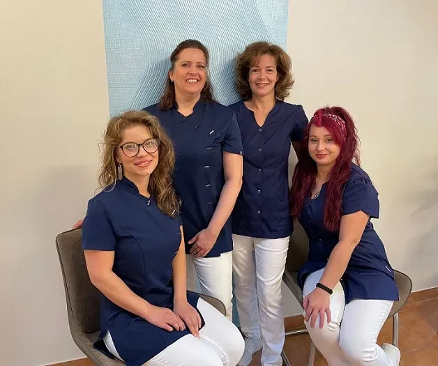 Neues Teamfoto von vier Mitarbeiterinnen in blauer Berufskleidung