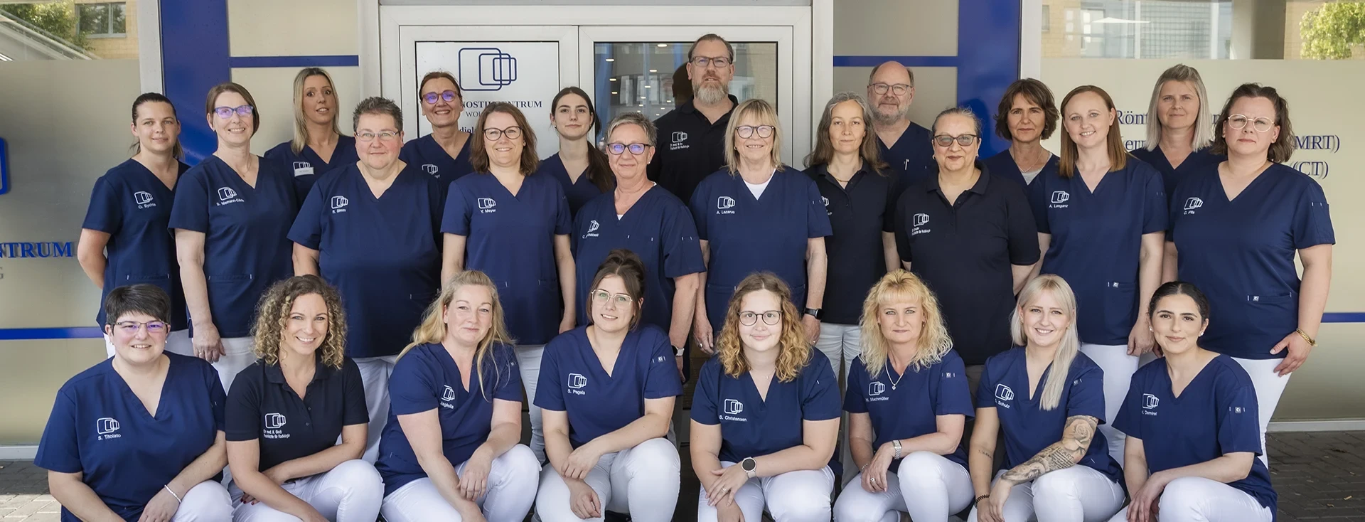 Teamfoto des medizinischen Fachpersonals vor dem Eingang des Zentrums