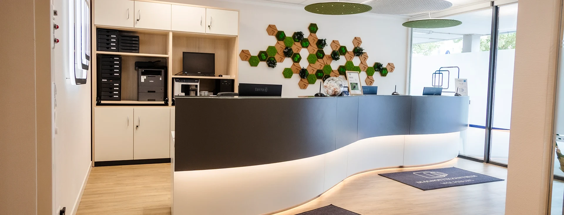 Moderner Empfangsbereich mit Sponsoring-Header und Wanddekoration aus Moos und Holz