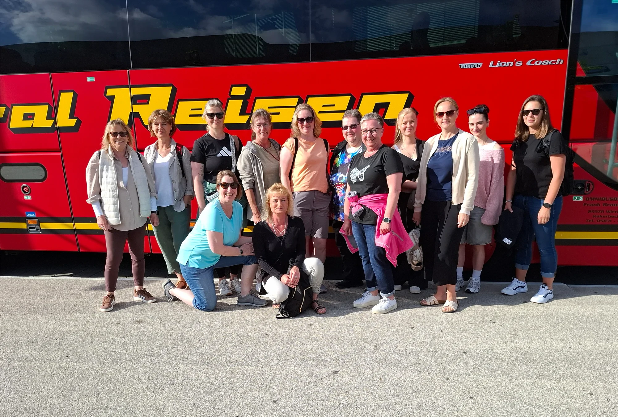 Gruppenfoto von Teilnehmern beim Sommerfest vor einem Reisebus