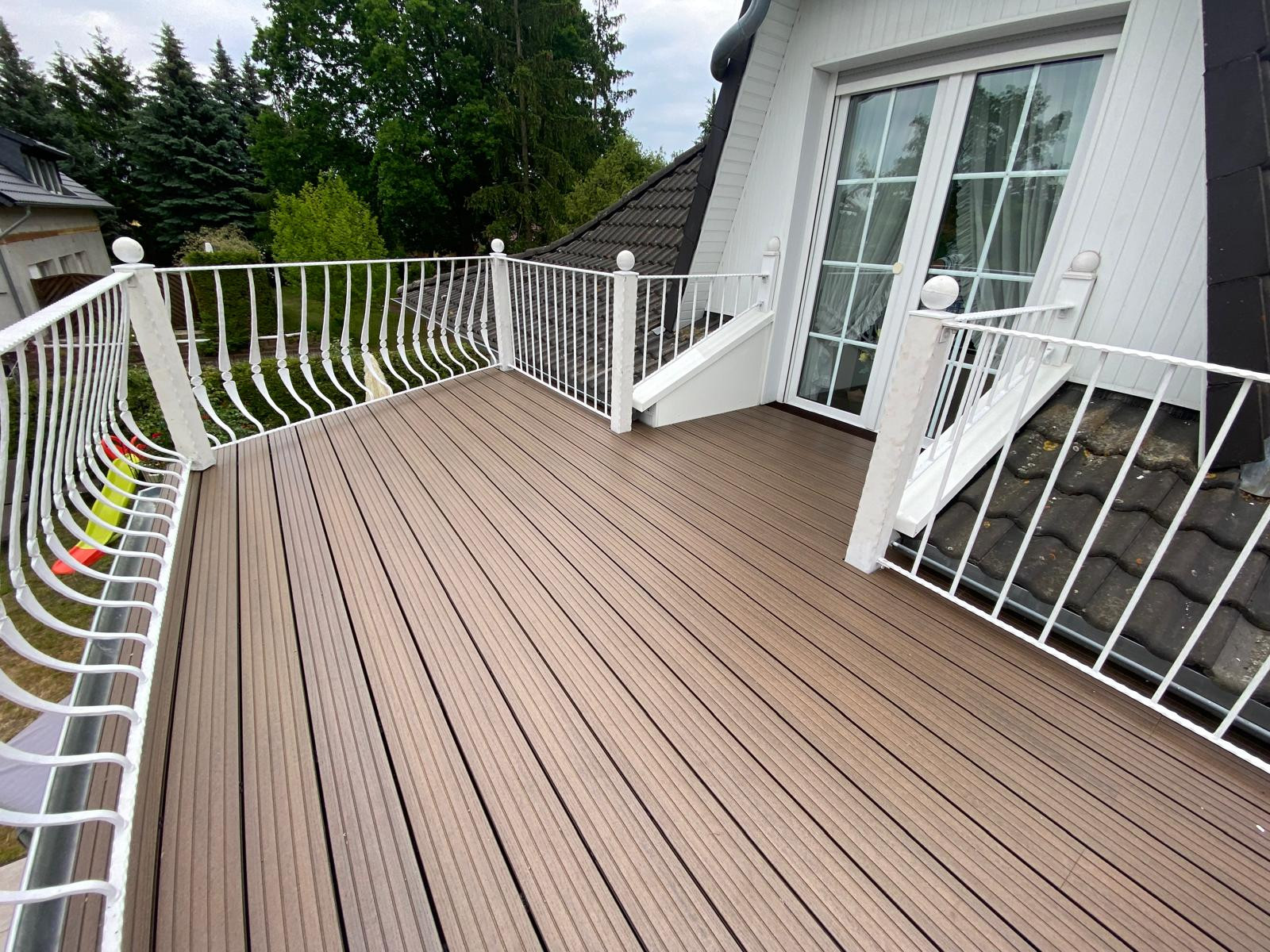 Moderne Dachterrasse in Maudach mit Holzoptik-Boden und weißem Geländer