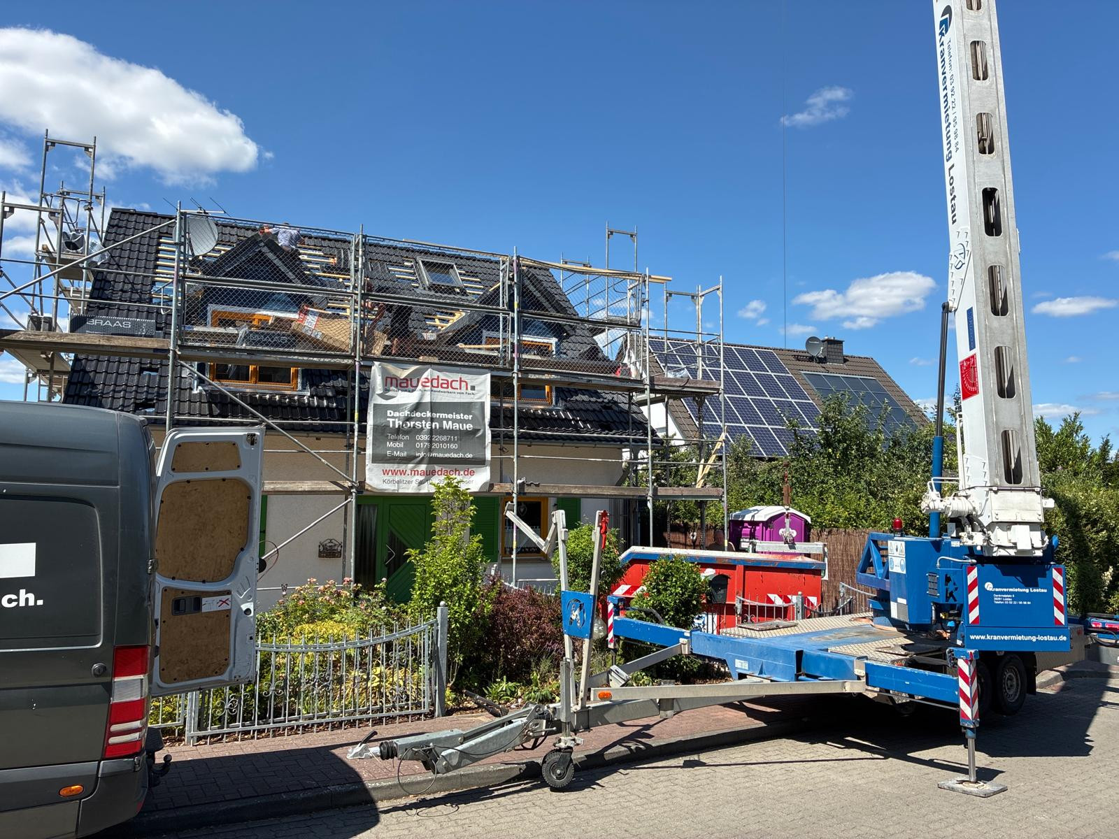 Dachsanierung in Maudach mit Baugerüst und Handwerkern bei sonnigem Wetter