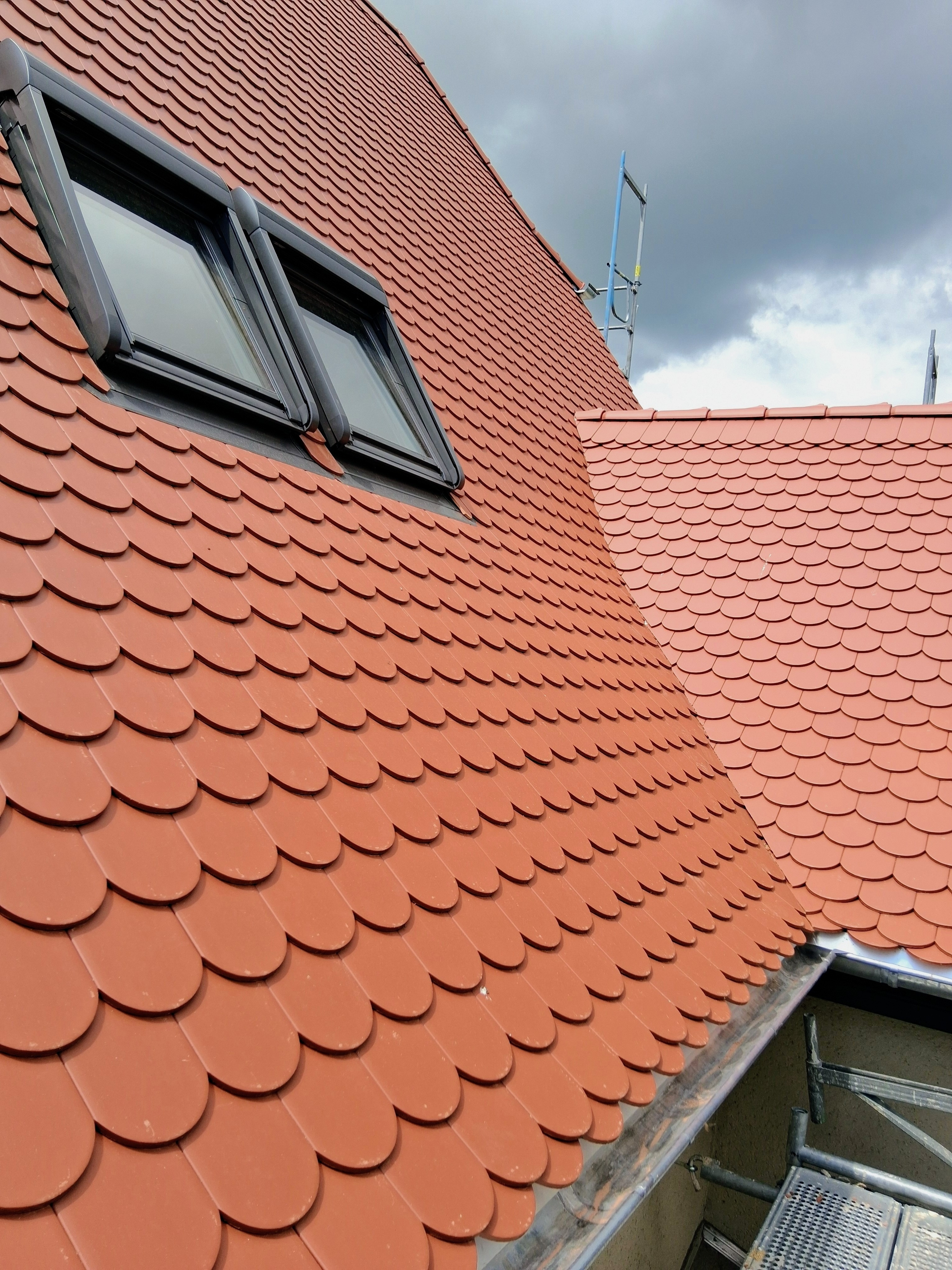 Historische Dächer Sanierung mit Biberschwanzziegeln – Detailaufnahme eines frisch gedeckten Daches mit typischen Biberschwanzziegeln