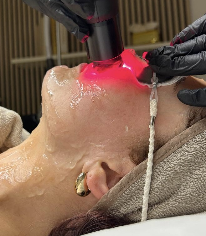 Frau bei einer Gesichtsbehandlung mit moderner Lasertherapie im Kosmetikstudio