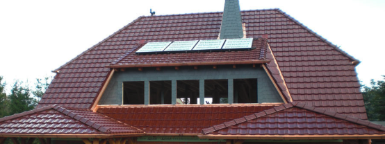 Dachdecken eines Hauses mit roten Ziegeln und Solarpanelen Hausdach mit roten Dachziegeln beim Dachdecken, teilweise fertiggestellt, mit Solarpanelen