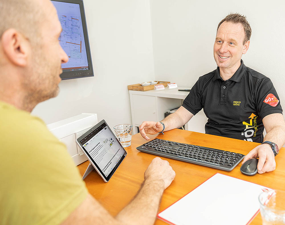 Beratungsgespräch im Büro mit Heiko Götz, Tablet und Tastatur auf dem Tisch