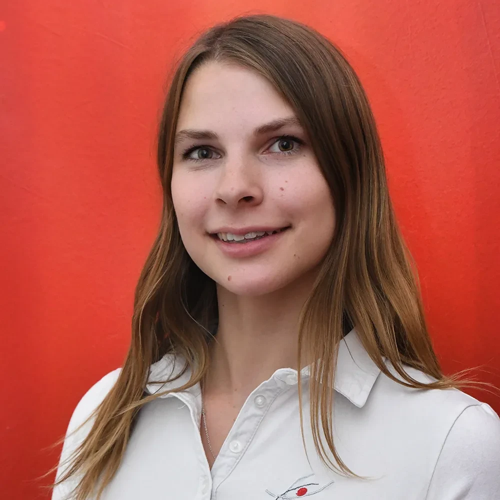 Porträtfoto von Nadja Lapsit vor rotem Hintergrund