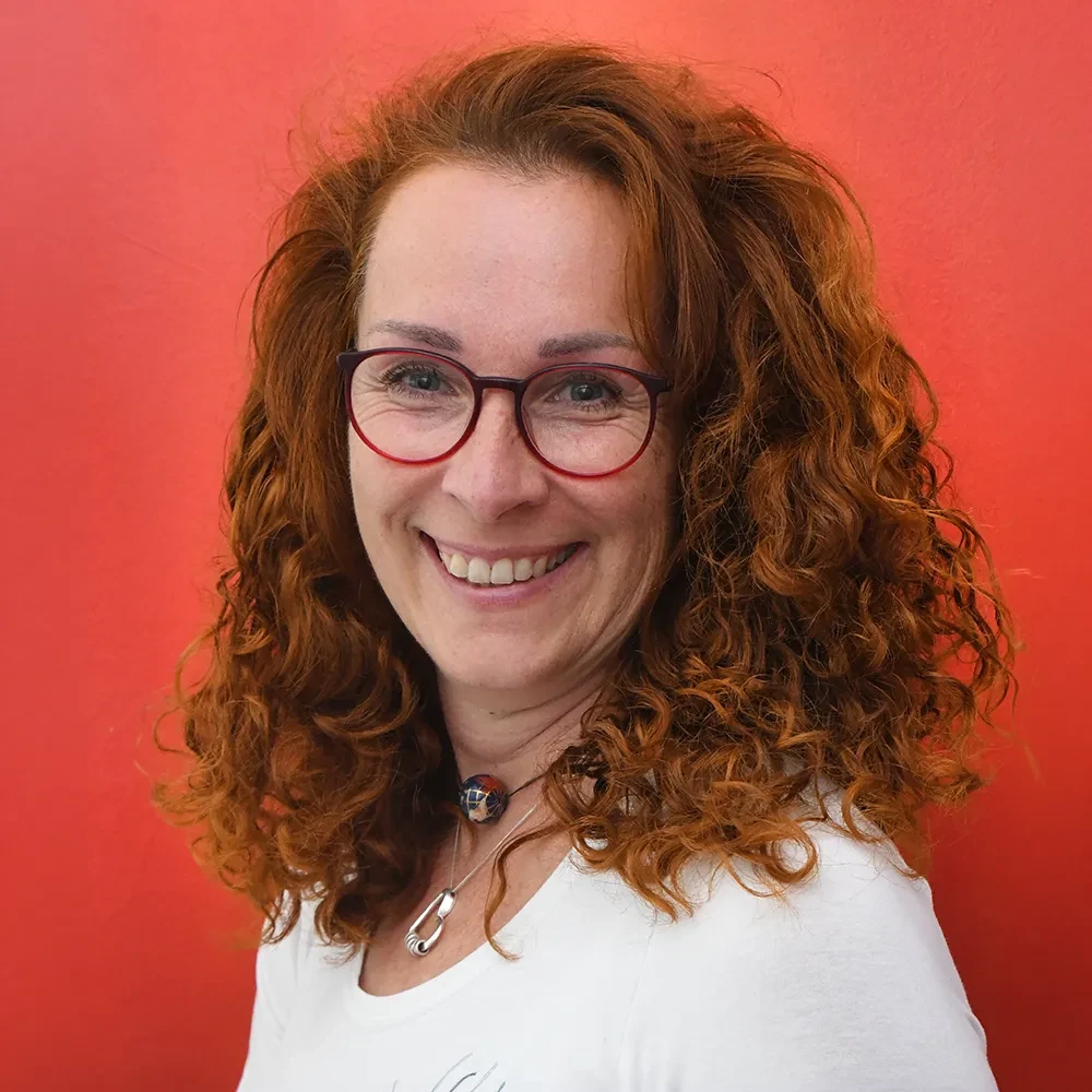 Portrait von Carina Hein vor rotem Hintergrund