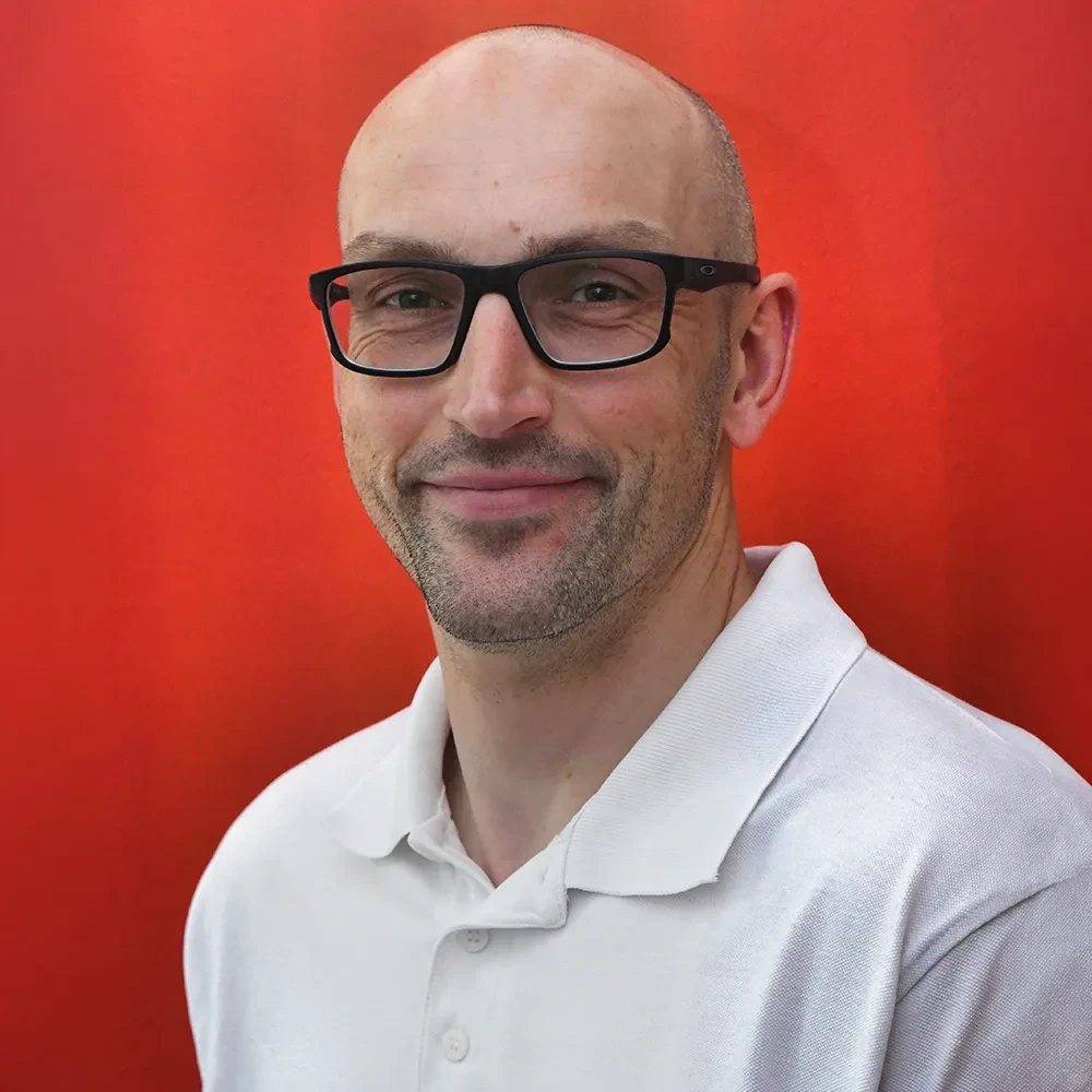 Portrait von Marcel Krahmann vor rotem Hintergrund