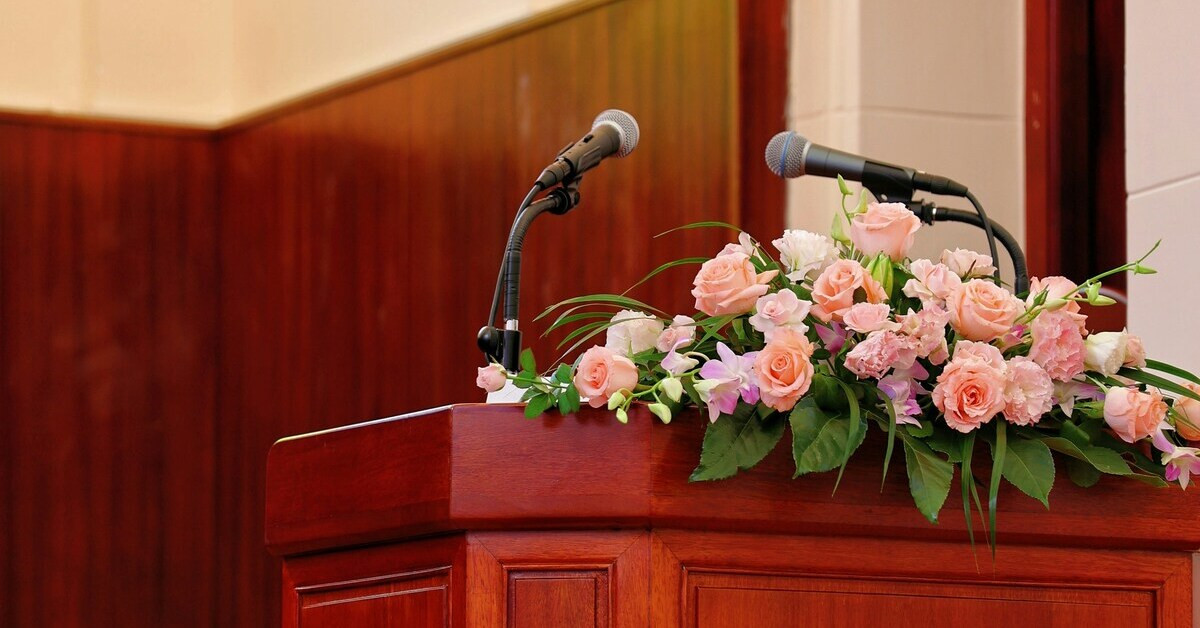Rednerpult mit Blumenarrangement und Mikrofon fcr eine Trauerrede