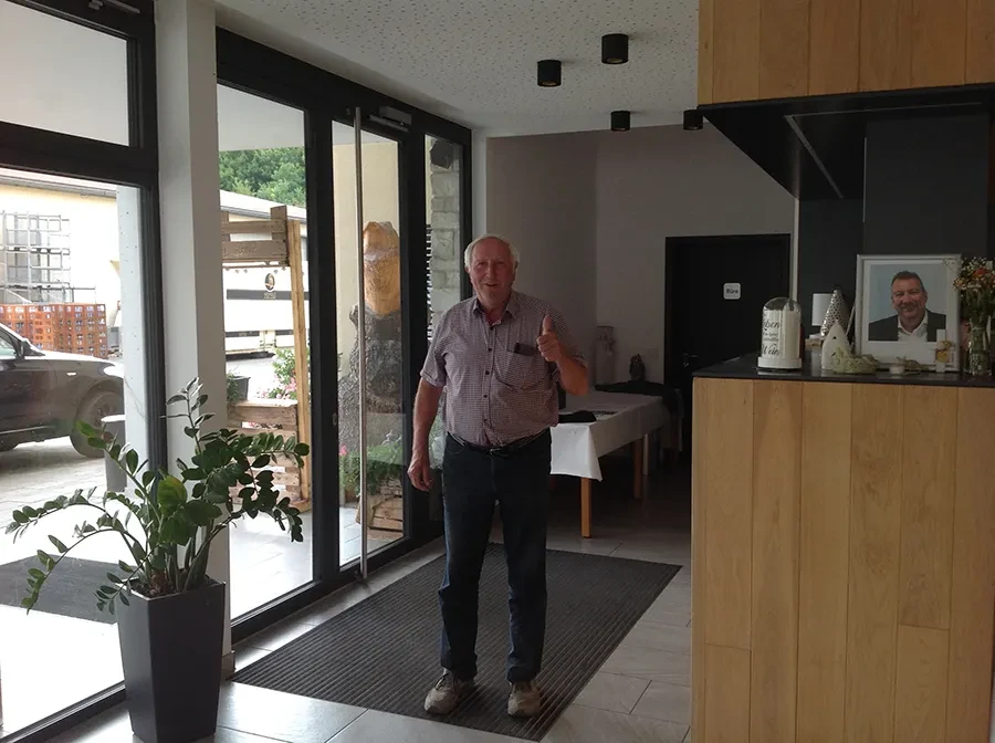 Person steht im Eingangsbereich mit Daumen hoch, aluhebe-2242 Hauptbild