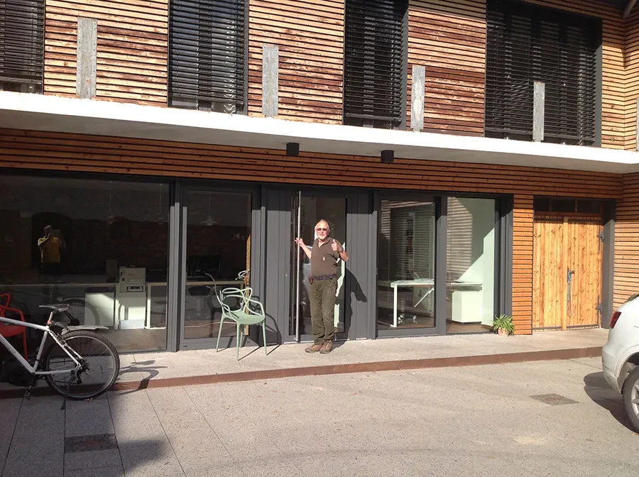 Falt-Schiebe-Tür aus Glas an moderner Holzfassade eines Gebäudes