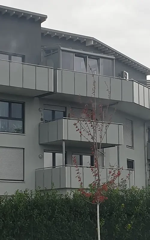 5456 Hauptbild eines modernen Mehrfamilienhauses mit Balkonen und grauer Fassade