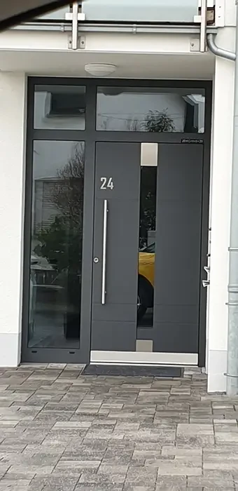 Moderne Haustür aus Metall mit Hausnummer 24 und großem Glaseinsatz