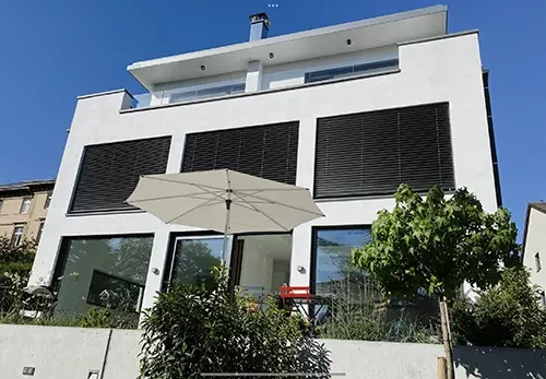 Modernes Einfamilienhaus mit Sonnenschirm und Garten – Hauptbild