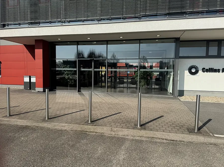 Hauptbild eines modernen Gebäudeeingangs mit Glasfront und Pflastersteinen