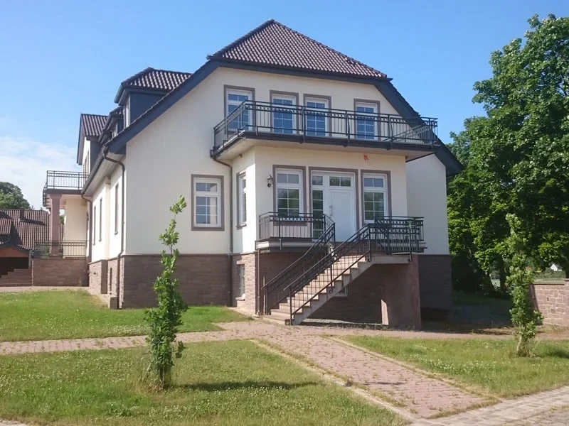 Sanierung von Wohngebäude – modernisiertes Mehrfamilienhaus mit neuem Anstrich und saniertem Dach