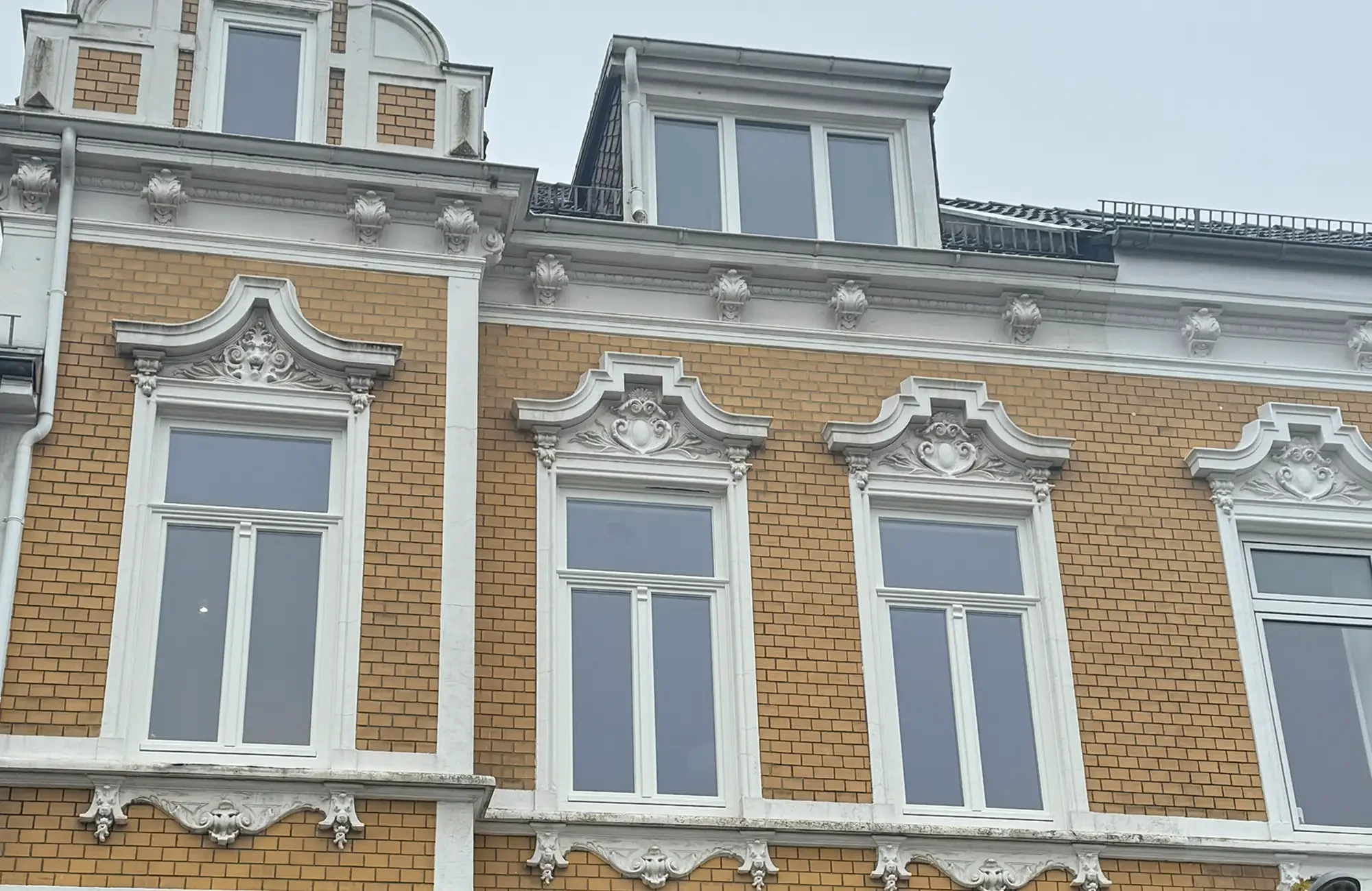 Historische Fenster mit Stuckverzierungen an einer Fassade eines Altbaus